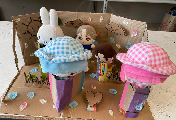 Constructed with cardboard, faux flower petals, and leaves.